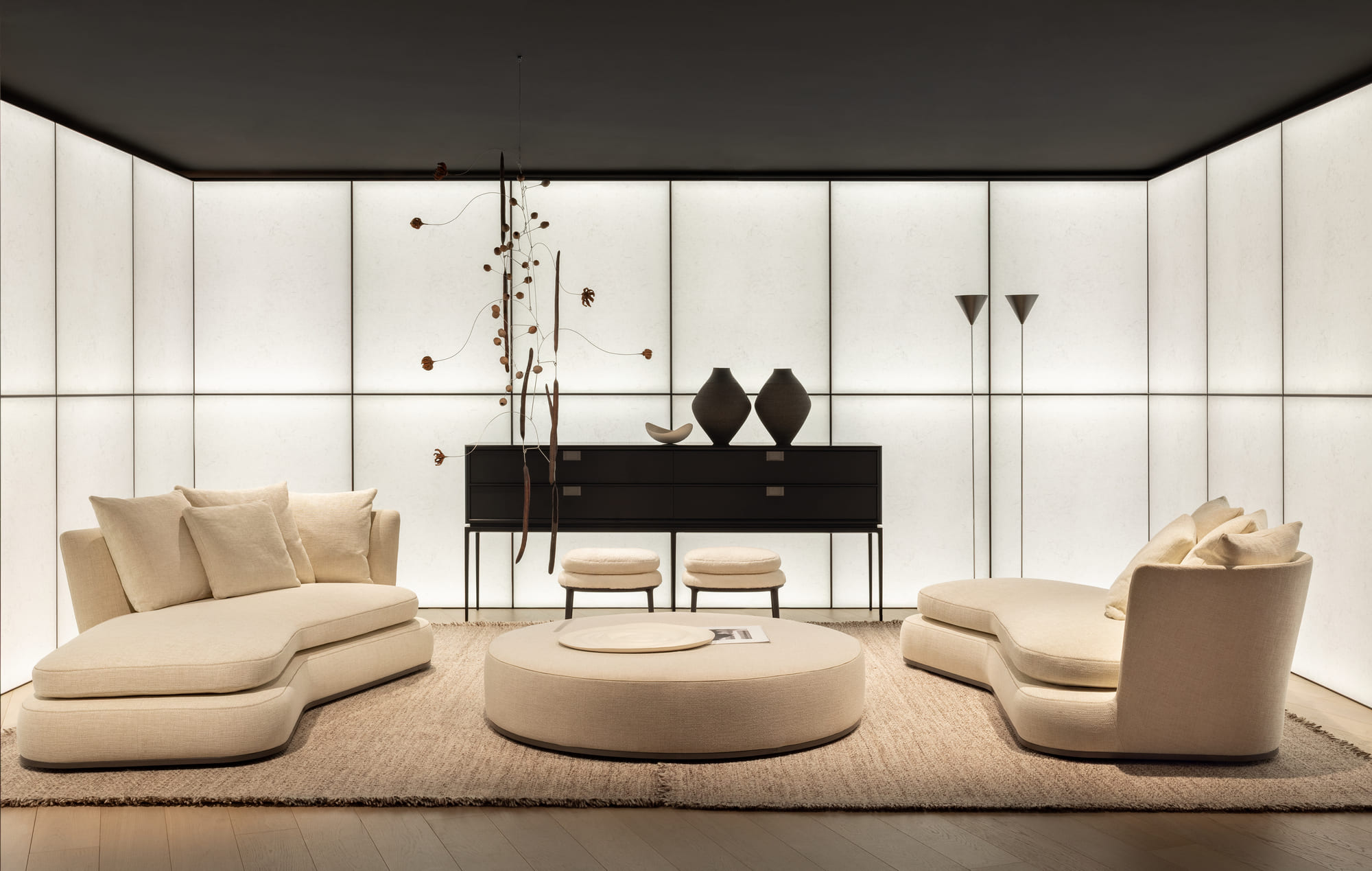 Canapés courbes Maxalto devant un mur lumineux, showroom de Milan, 2025